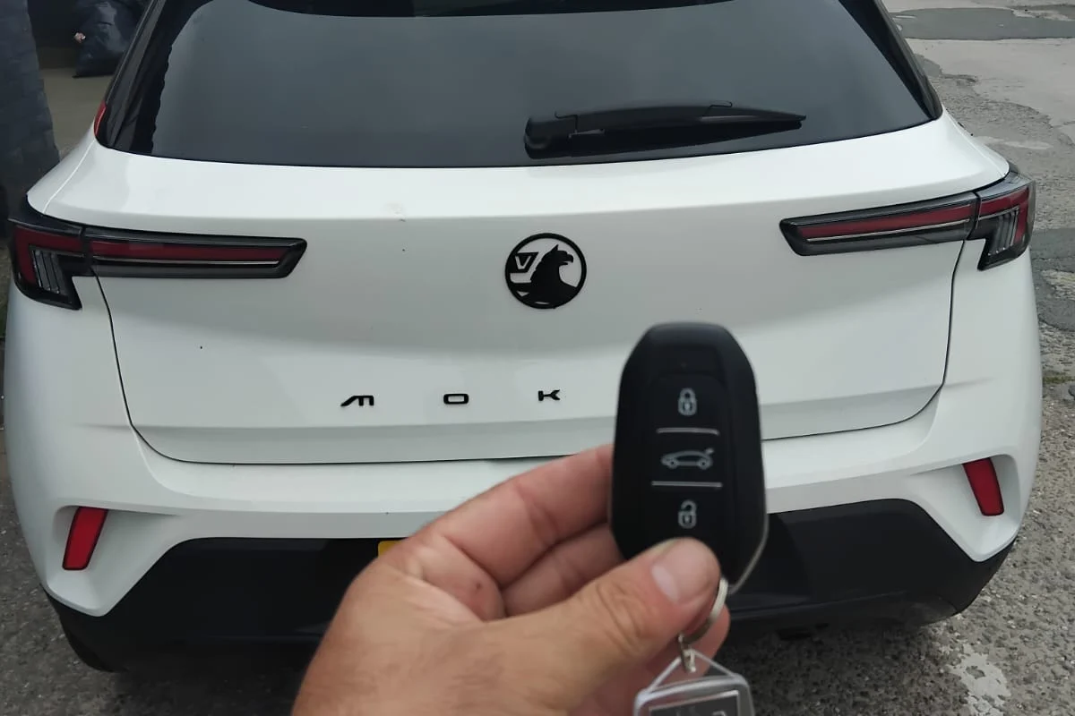 New remote key tested beside a white hatchback